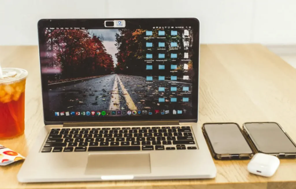 Laptop on table, next to two phones