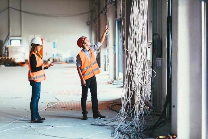 Electricians checking wires on construction site