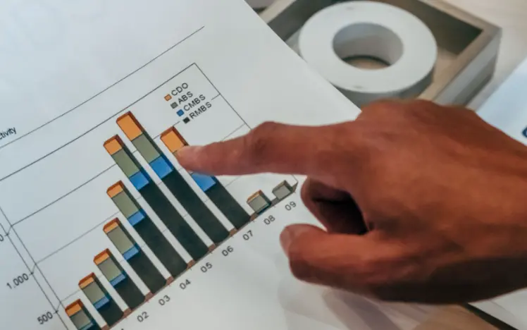 Hand pointing at charts on paper