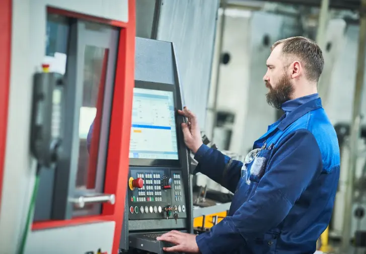 Man operating production machine in factory