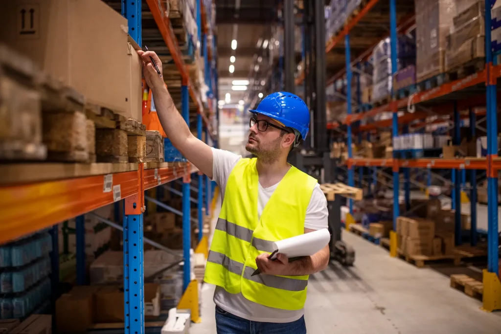 Warehouse worker in warehouse, checking shelves