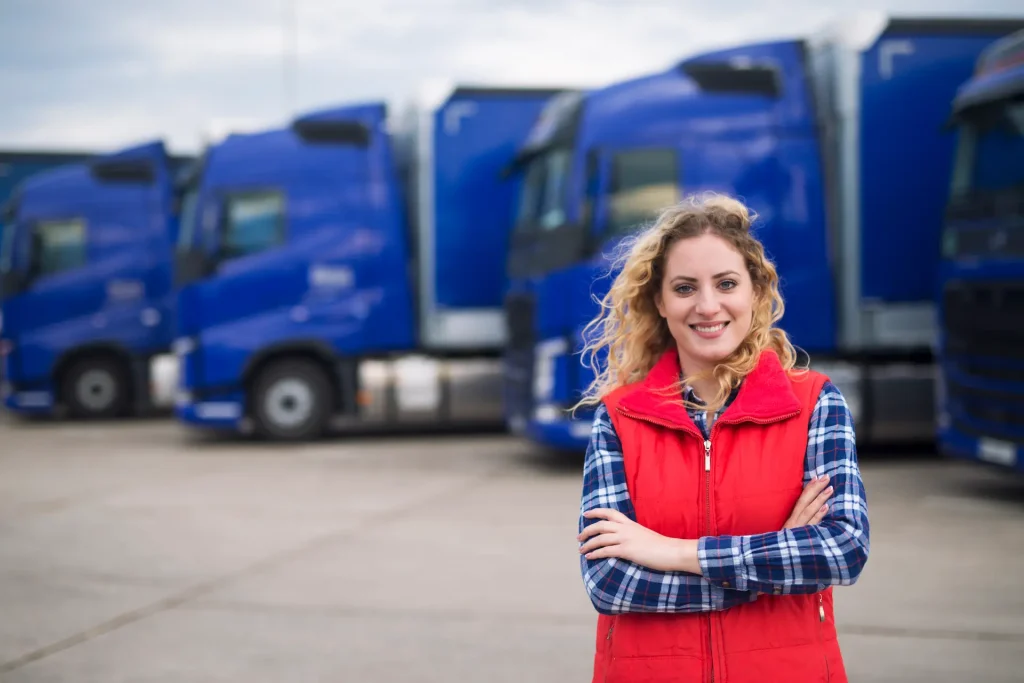 female truck driver in front of trucks