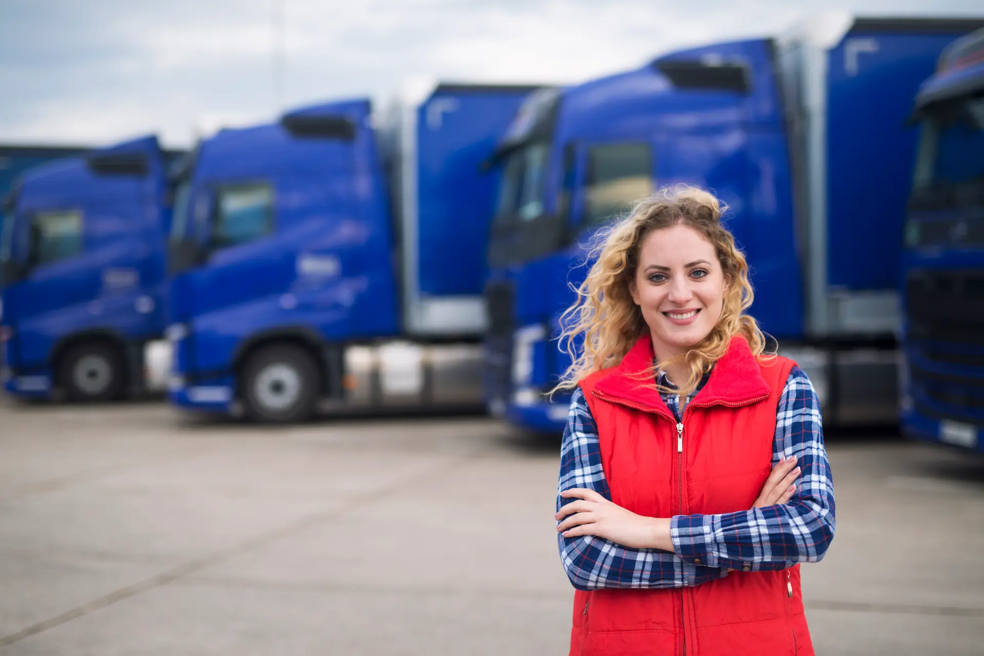female truck driver in front of trucks